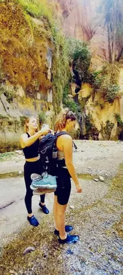 two women standing next to a painting of a mountain at - Trekking from Dana to Petra in Dana