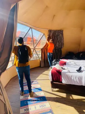two people standing in a room looking out of a window at Wadi Rum Desert Bedouins in Wadi Rum
