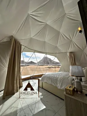 a bedroom with a tent with a view of the desert at Angelina Luxury Camp in Wadi Rum