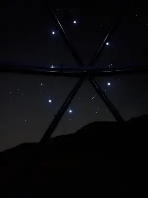a view of the night sky from an umbrella at SARAB Luxury Camp in Wadi Rum
