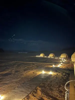 a group of lights on the beach at night at SARAB Luxury Camp in Wadi Rum
