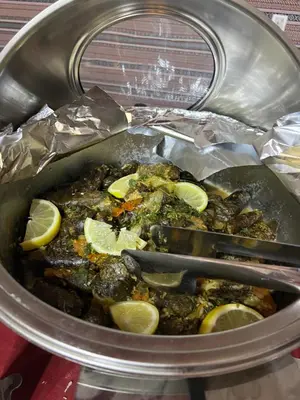 a pot of food with lemon slices in it at SARAB Luxury Camp in Wadi Rum