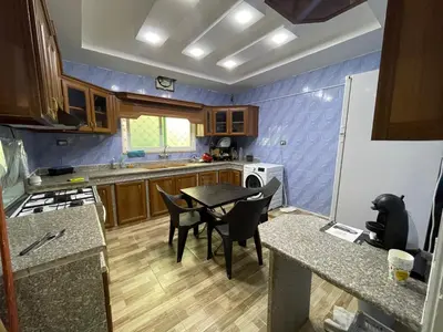 a kitchen with a table and chairs in it at Oskar Appartment in Wadi Musa