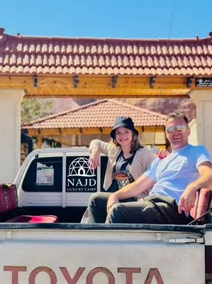 a man and a woman sitting in the back of a truck at Najd Luxury Camp in Wadi Rum