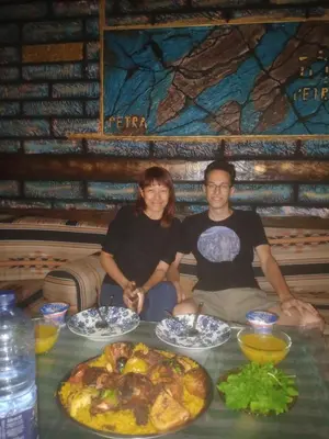 a man and woman sitting at a table with food at Petra Musa Rural House in Wadi Musa