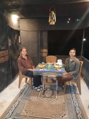 two women sitting at a table in a room at Petra Musa Rural House in Wadi Musa