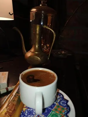 a cup of coffee on a table with a tea pot at Petra Musa Rural House in Wadi Musa