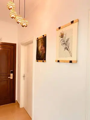 a hallway with two pictures on a wall and a chandelier at Lovely 3 bedrooms rental unit in Aqaba