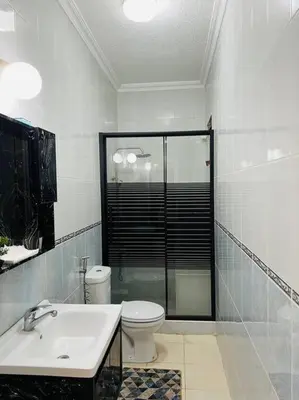 a bathroom with a shower and a toilet and a sink at Lovely 3 bedrooms rental unit in Aqaba