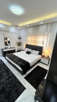 a bedroom with a large bed in a room at شقة مفروشة بغرفتي نوم الجاردنز in Umm Uthainah