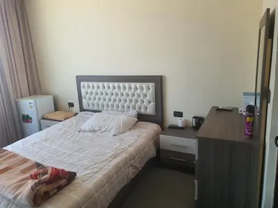 a small bedroom with a bed and a desk at Alfares Hotel in At-Tafilah