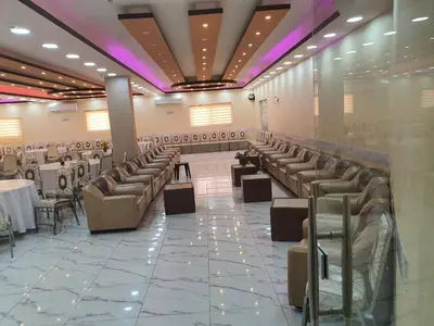 a banquet hall with chairs and tables and purple lighting at Alfares Hotel in At-Tafilah