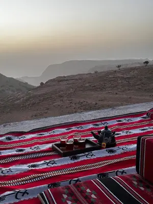 a table with food on top of a rug in the desert at Alnwatif Gate guest house Dana nature reserve in Dana