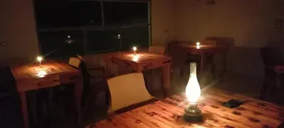 a room with two tables with lit candles on them at Alnwatif Gate guest house Dana nature reserve in Dana