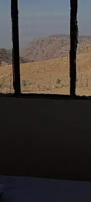 a view of the desert from a window in a room at Alnwatif Gate guest house Dana nature reserve in Dana
