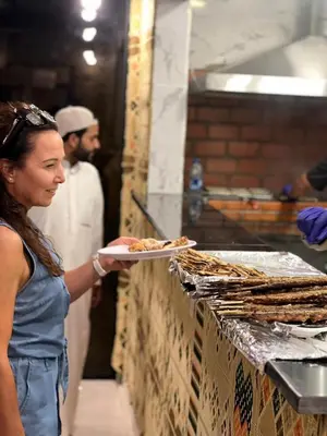 a woman is holding a plate of food at Charlotte luxury camp in Wadi Rum