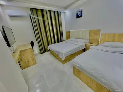 a hotel room with two beds and a television at رويال جروب اربد Royal Group Hotel in Irbid