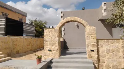 an entrance to a building with a stone arch at Wadi Al-Nakhil Hostel in Al Khuraybah