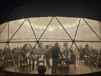a group of people sitting at tables in a tent at MAXIMAS LUXURY Wadi Rum in Wadi Rum
