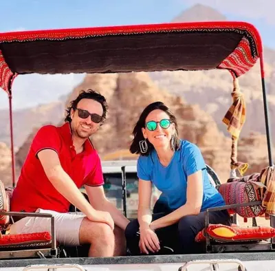 a man and a woman sitting on a boat at Tamim Luxury wadi rum camp in Wadi Rum