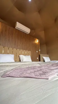 a large bed with a pink blanket on top of it at SELEN RUM LUXURY CAMP & Jeep Tours in Wadi Rum