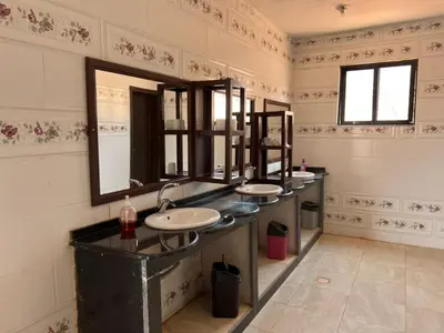 a bathroom with three sinks and a large mirror at Wadi Rum Time in Wadi Rum