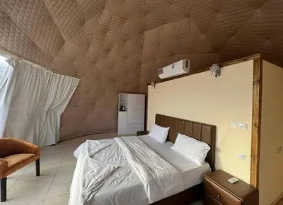 a bedroom with a large bed with a wooden ceiling at Amazing Wadi Rum Camp in Wadi Rum