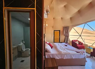 a bedroom with a bed in a room with a window at Amazing Wadi Rum Camp in Wadi Rum