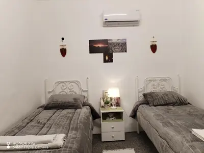 a bedroom with two beds and a tv on the wall at Seleucia DaR Umm Qais in Um Qeis