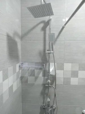 a shower in a bathroom with a glass door at EMILE ALTWAL Hotel in Madaba