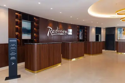 a hotel lobby with a hotel sign on the wall at Radisson Blu Hotel, Amman Galleria Mall in Amman