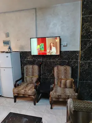 two chairs in a room with a tv on the wall at شقة ام نوارة الحديثة modern nice flat in Amman