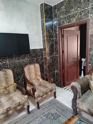 a living room with two chairs and a tv at شقة ام نوارة الحديثة modern nice flat in Amman