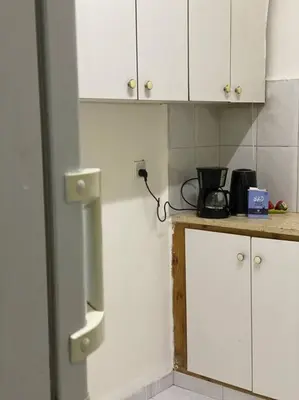 a kitchen with white cabinets and a counter top at Homey Apt. with beautiful view in Amman