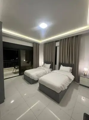 a hotel room with two beds and a fireplace at cozy home near all services 20 in Rujm ash Sharāʼirah