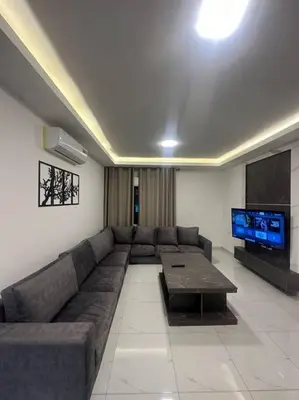 a living room with a couch and a flat screen tv at cozy home near all services 20 in Rujm ash Sharāʼirah