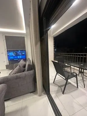a view of a balcony with a couch and a table at cozy home near all services (21) in Rujm ash Sharāʼirah