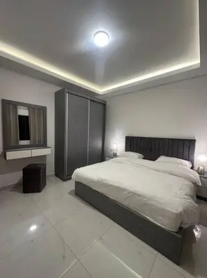 a bedroom with a large bed and a tv at cozy home near all services (19) in Rujm ash Sharāʼirah