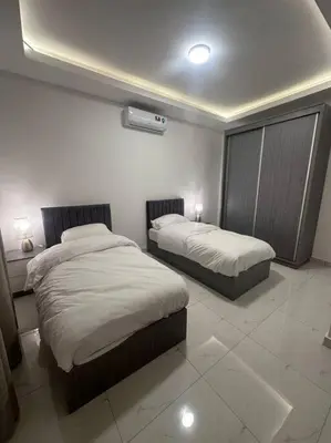 a bedroom with two beds in a room at cozy home near all services (19) in Rujm ash Sharāʼirah