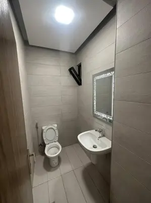 a small bathroom with a toilet and a sink at cozy home near all services (19) in Rujm ash Sharāʼirah