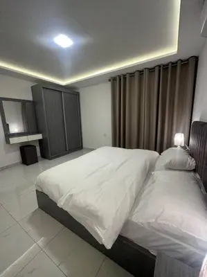 a bedroom with a large white bed in it at cozy home near all services (22) in Rujm ash Sharāʼirah