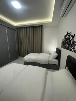 a hotel room with two beds and a couch at cozy home near all services (22) in Rujm ash Sharāʼirah