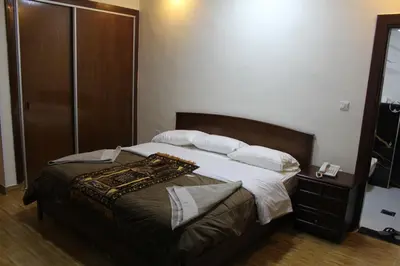a bedroom with a large bed with white sheets and pillows at الأحفاد للشقق الفندقية Al Ahfad Hotel Apartments in Şāfūţ
