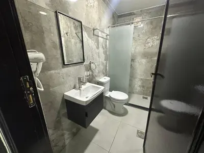 a bathroom with a toilet and a sink and a shower at Happy Beach Castel for Apartment قلعة شاطئ السعادة للشقق المفروشة in Aqaba