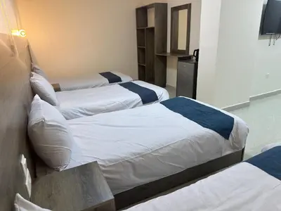 three beds in a hotel room with a tv at Happy Beach Castel for Apartment قلعة شاطئ السعادة للشقق المفروشة in Aqaba