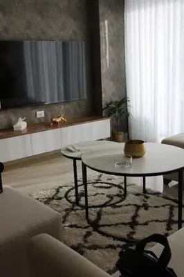 a living room with a table and a tv at Abdoun luxurious apartment in Amman