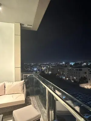 a room with a couch and a view of a city at Abdoun luxurious apartment in Amman