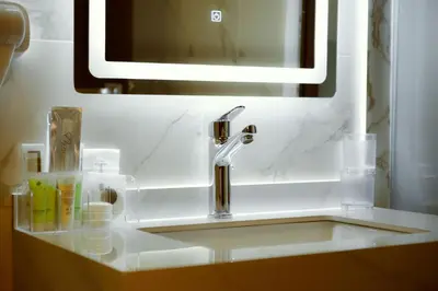 a bathroom sink with a faucet and a mirror at Petra Bermudez Hotel in Wadi Musa
