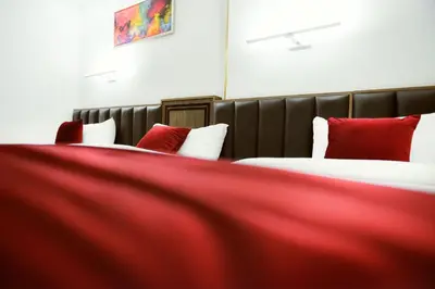 two beds with red pillows in a room at Petra Bermudez Hotel in Wadi Musa