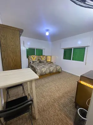 a bedroom with a bed and a table in a room at شقه مفروشه مميزه in Irbid
